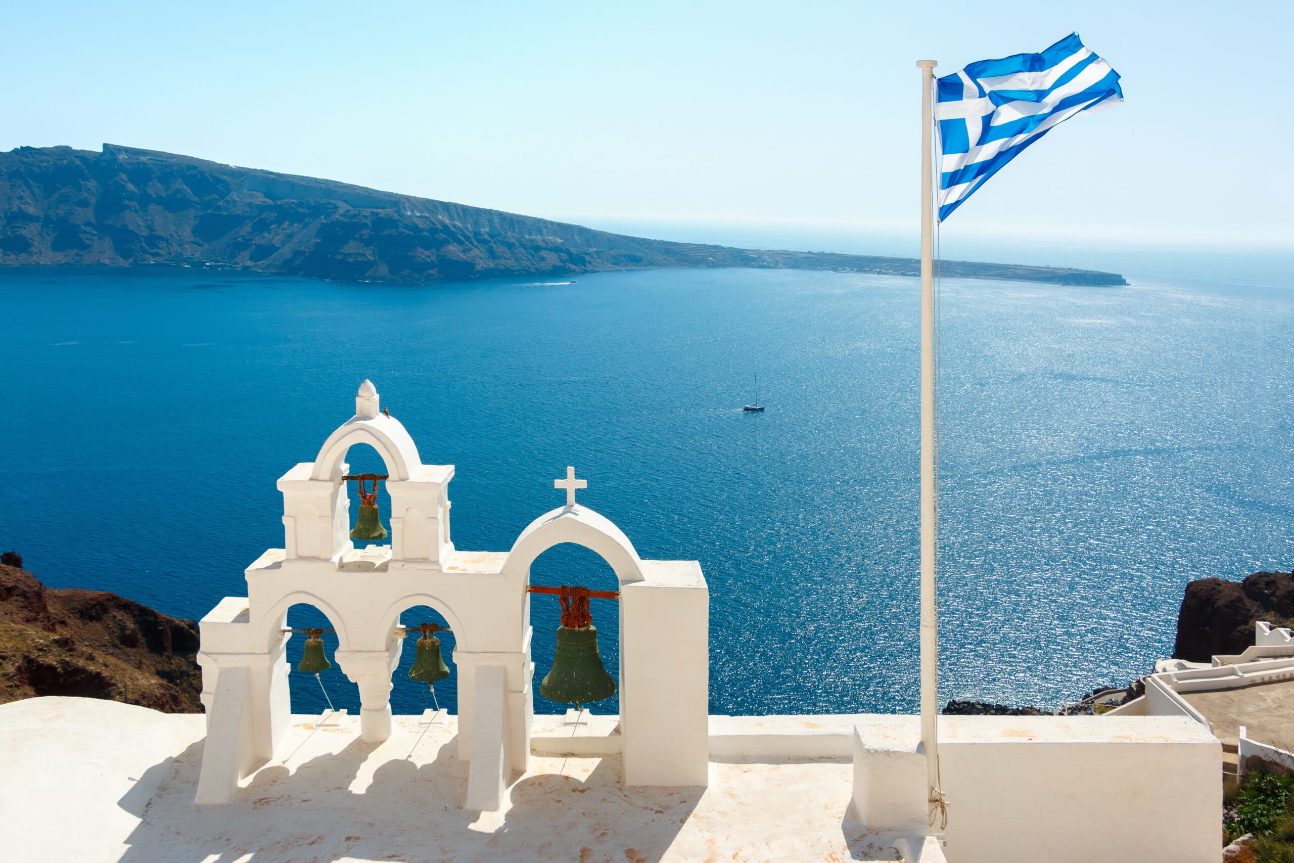 Bell,Towers,And,Greek,Flag,In,Oia,Town,,Santorini,Island,