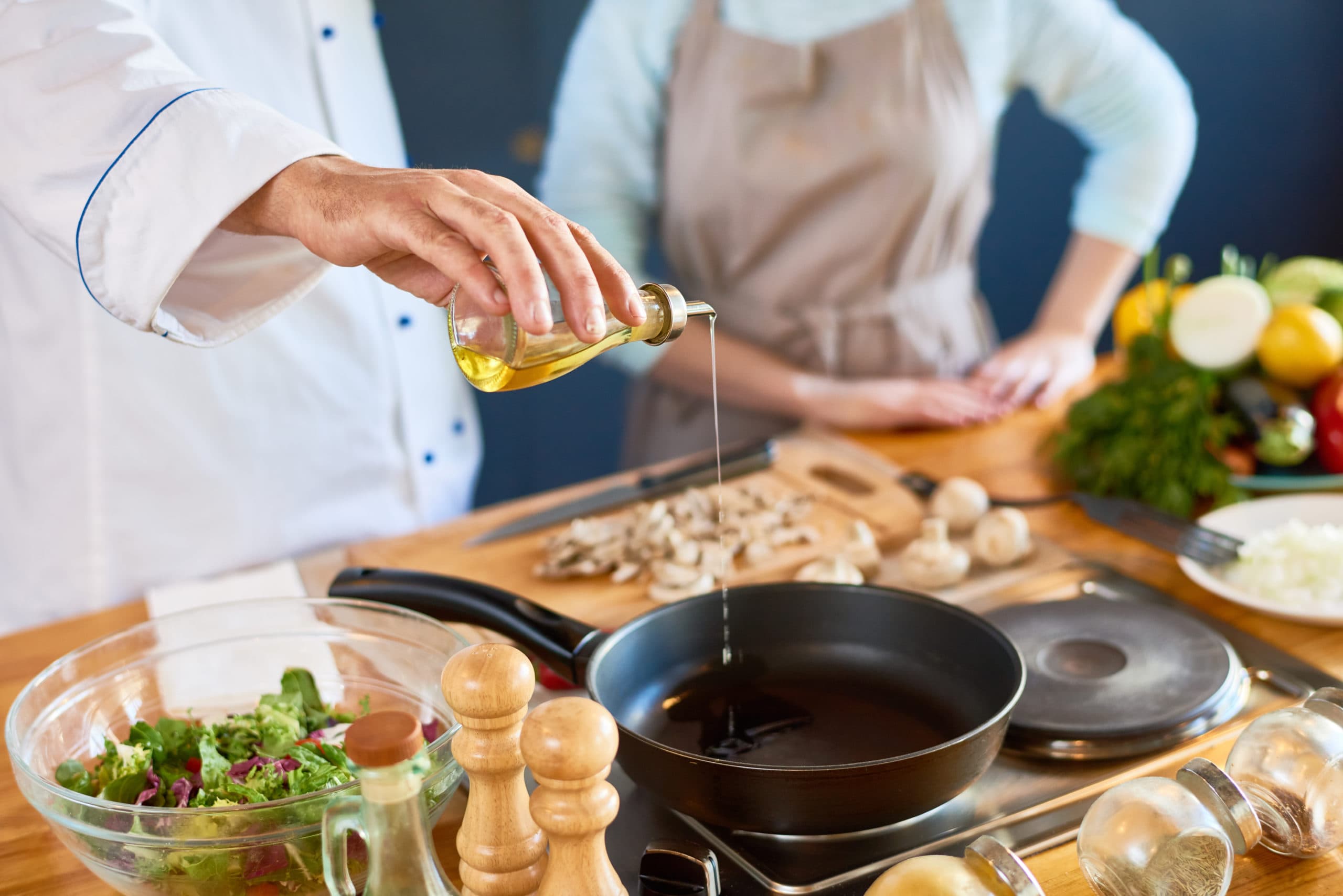 Close-up,Of,Male,Chef,Pouring,Oil,Into,The,Pan
