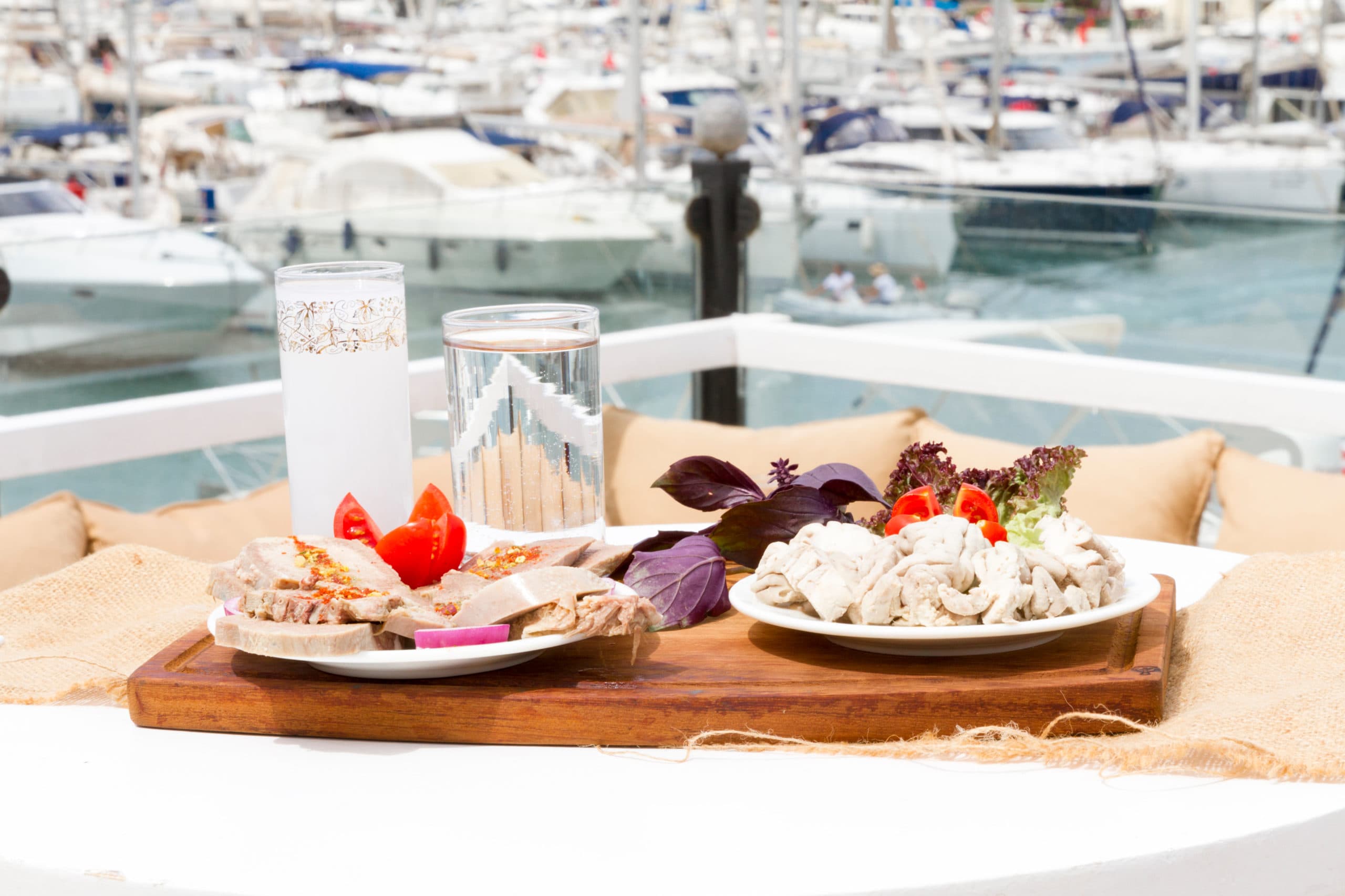 Restaurant,At,A,Sea,Shore,Against,Blue,Water,And,Yacht