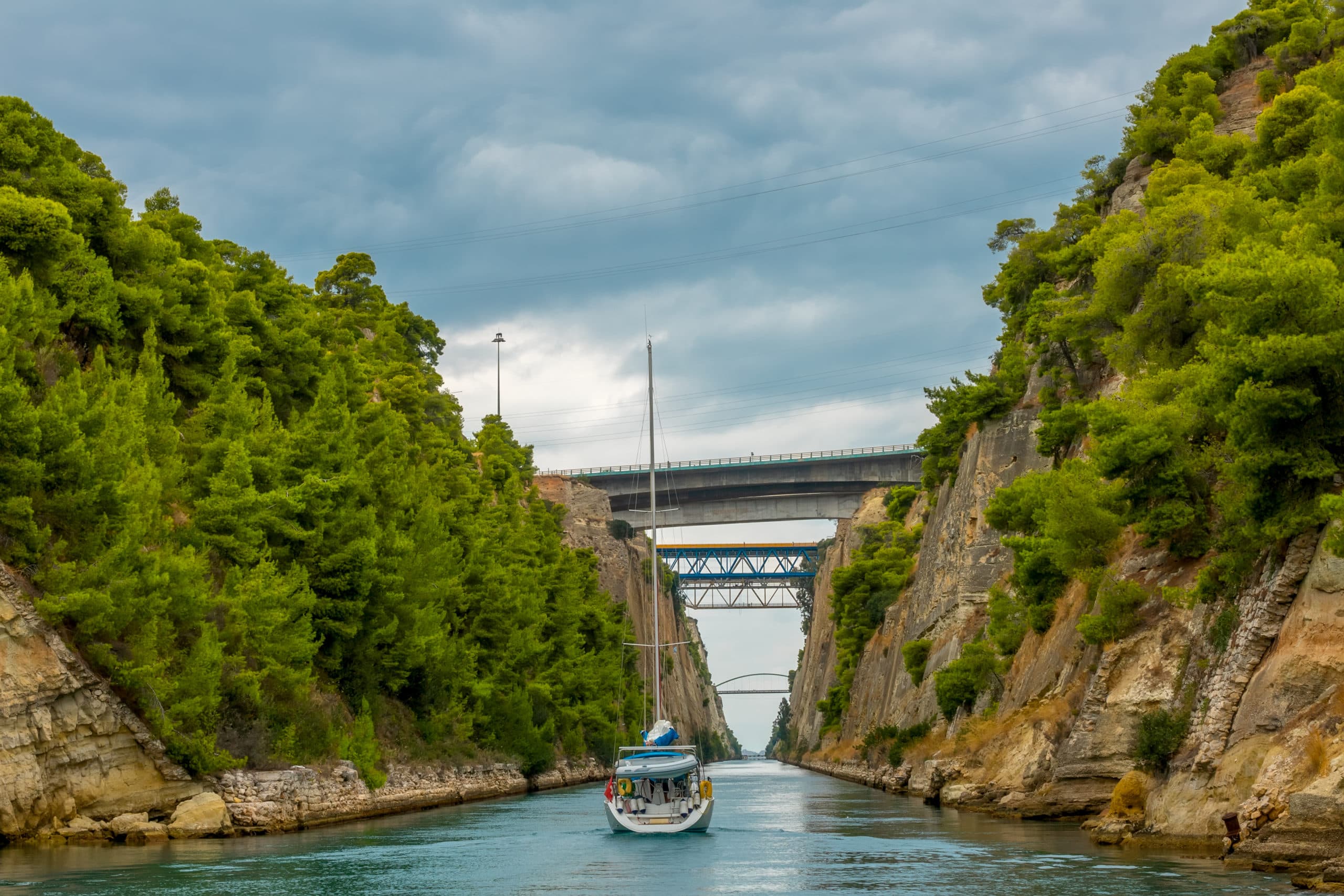 Greece.,Corinth,Canal,In,Cloudy,Weather.,Several,Bridges.,Sailing,Yacht