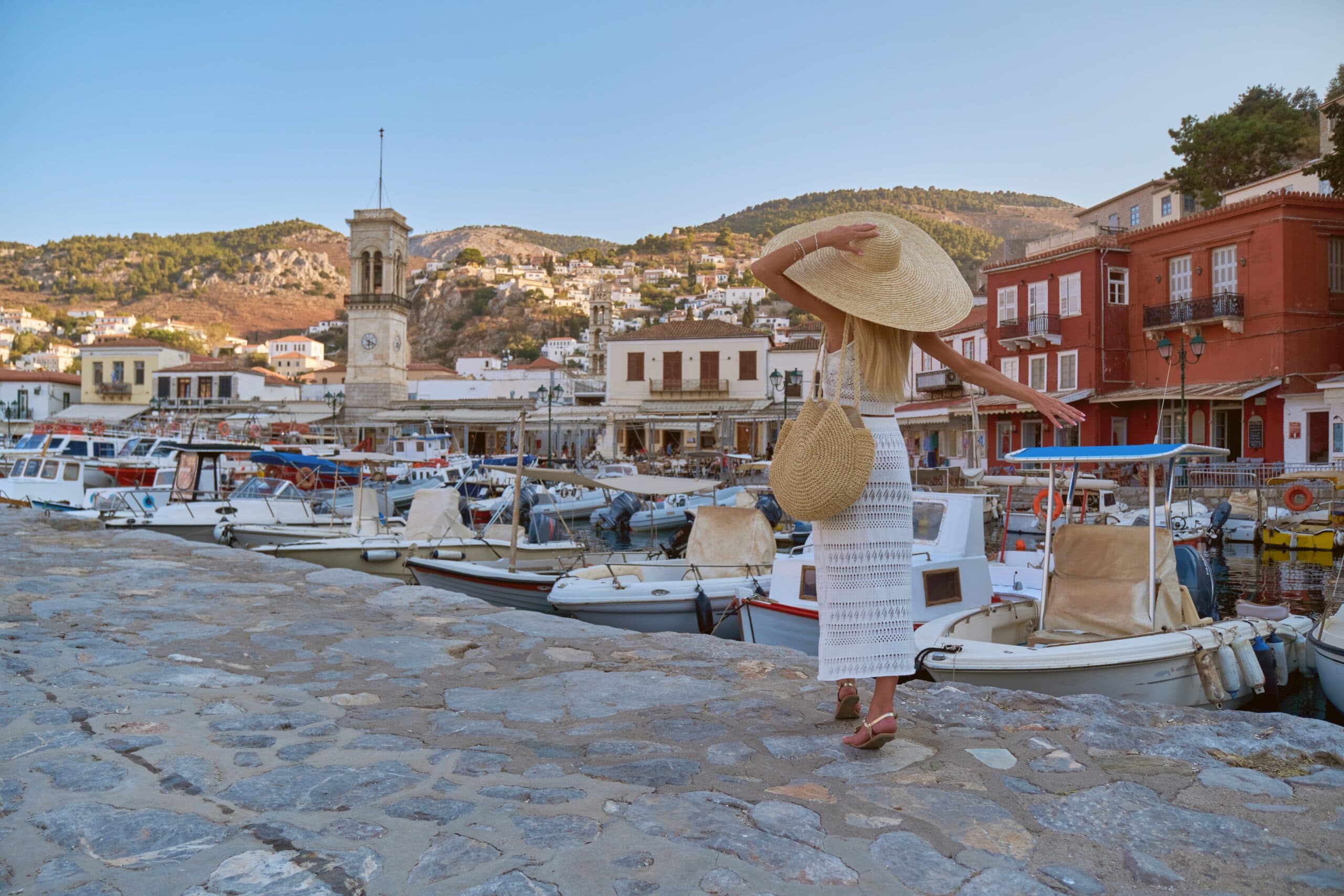 Young,Lady,Wearing,Dress,And,Straw,Hat,Walking,In,Marina.